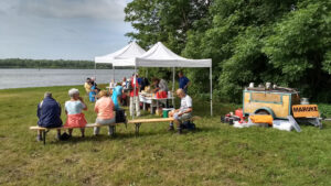 Wandelaars nemen een pauze bij een verzorgingspost aan het water.